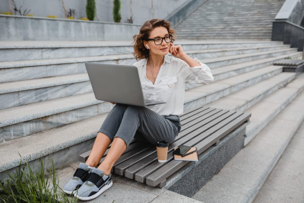 attractive stylish smiling woman glasses working typing laptop